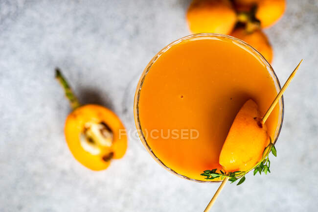 Top view of fresh juice glass with loquats on concrete surface — Stock Photo