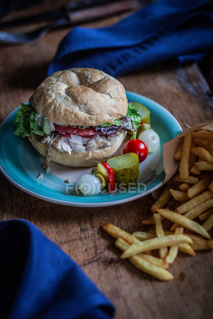 Fish burger and French fries with pickled vegetables — Stock Photo