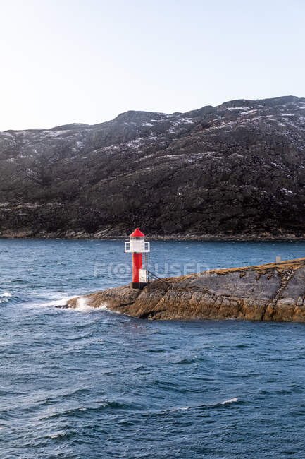 Lighthouse on rocks and sailing speed limit sign, Norway — Stock Photo