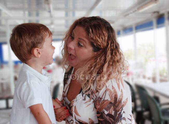 Mother and son looking at each other pulling funny faces — Stock Photo