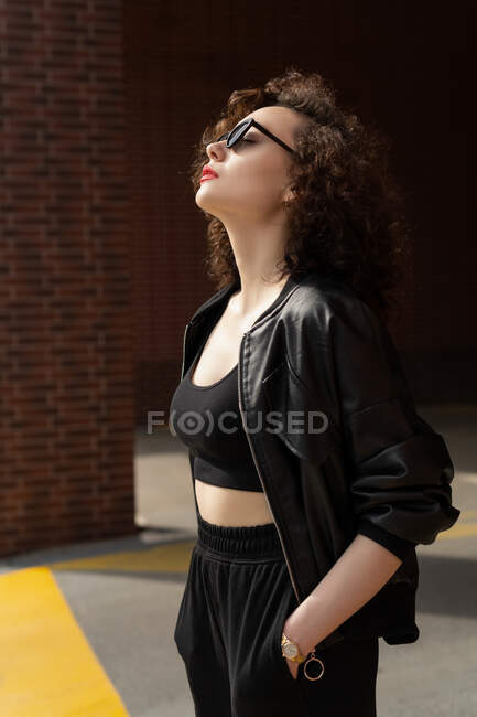 Belle femme debout dans la rue se prélasser au soleil — Photo de stock