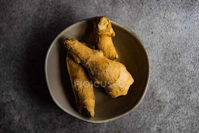 Bol en grès avec racine de gingembre comme concept alimentaire sain — Photo de stock