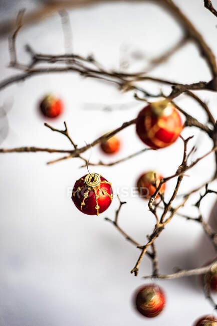 Weihnachtskartenkonzept mit trockenen Zweigen, dekoriert mit roten Kugeln im grauen Betoninnenraum — Stockfoto