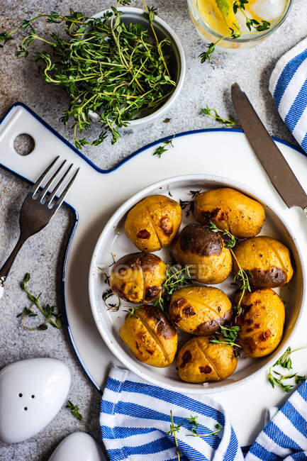 Delicious new potatoes in a bowl sprinkled with chopped thyme herb served on a concrete table — Foto stock