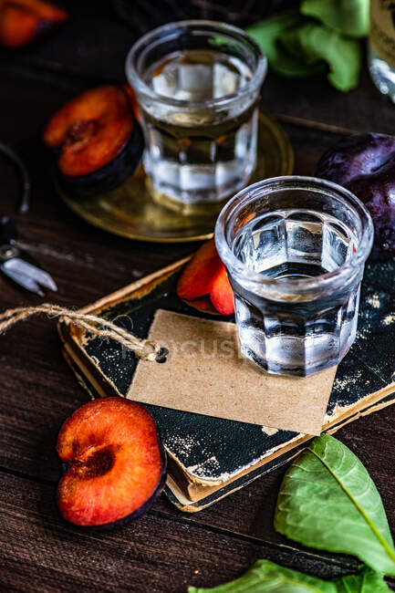 Vodka de ameixa servida em copos frios e ameixas frescas em uma mesa — Fotografia de Stock