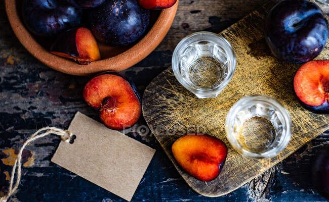 Плюмова горілка подається в холодних склянках і свіжих сливах на столі. — стокове фото