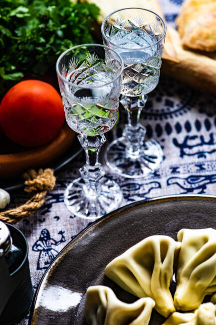 Traditional georgian supra with khinkali, vegetable set and chacha drink in glasses — Foto stock