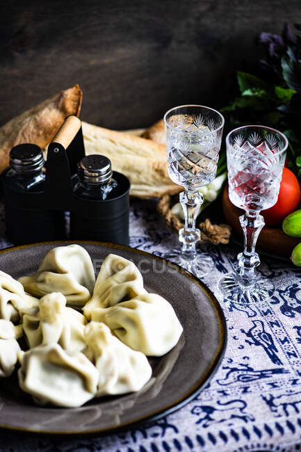 Traditional georgian supra with khinkali, vegetable set and chacha drink in glasses — Stock Photo