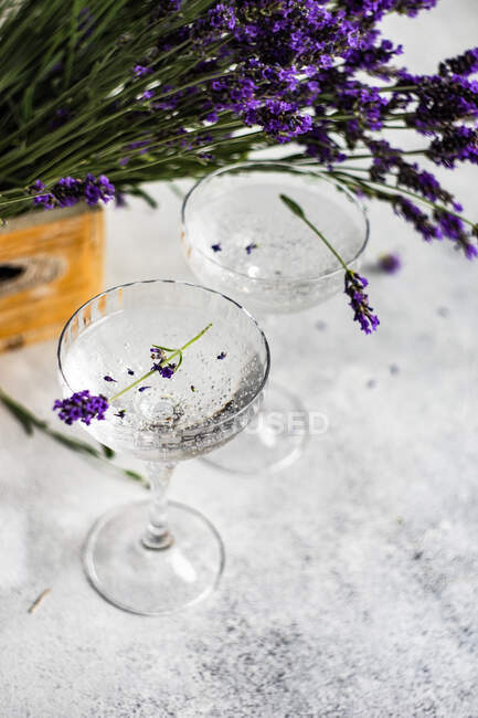 Vasos de limón gin tonic y flores de lavanda en una mesa - foto de stock
