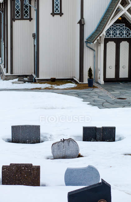 Primer plano de una iglesia y cementerio en la nieve, Gol, Noruega - foto de stock