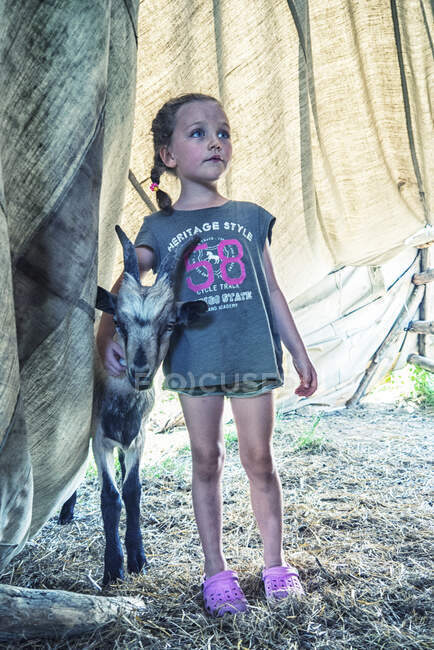 Girl standing in a tent with a goat, Poland — Stock Photo