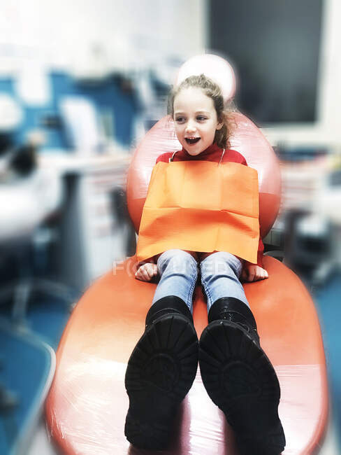 Sorridente ragazza seduta su una sedia dentista — Foto stock
