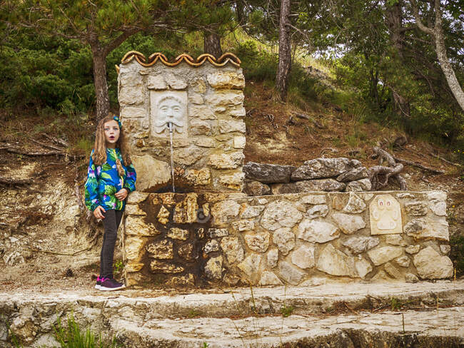 Menina em pé perto de uma fonte de água, Scanno, L 'Aquila, Abruzzo, Itália — Fotografia de Stock