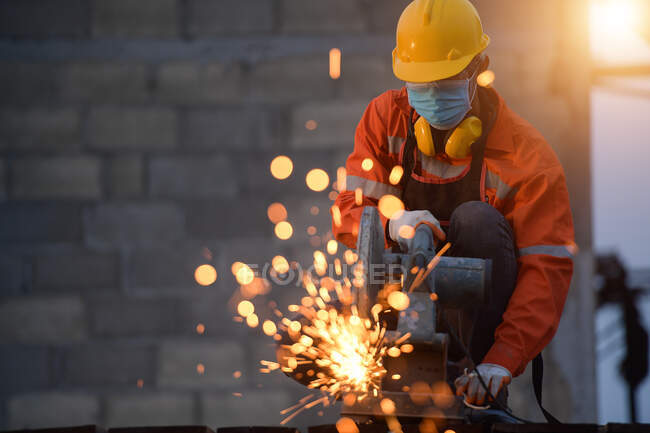 Acciaio tagliato dal lavoratore con tagliatrice disco circolare taglia parte del ferro fino a quando si verificano scintille durante il taglio dell'acciaio. — Foto stock