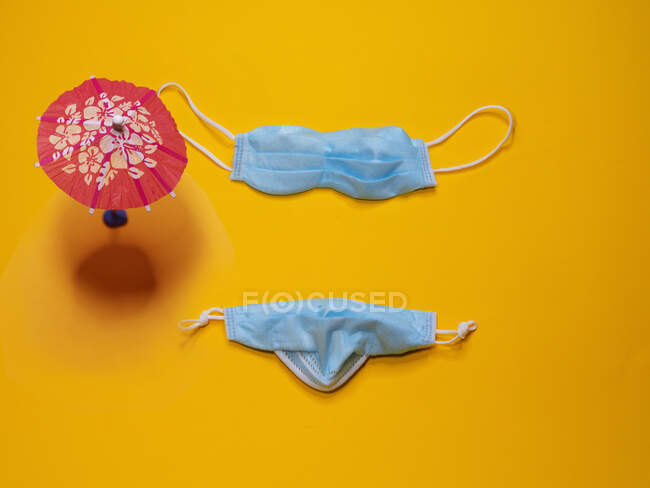 Conceptual bikini and parasol on the beach — Stock Photo