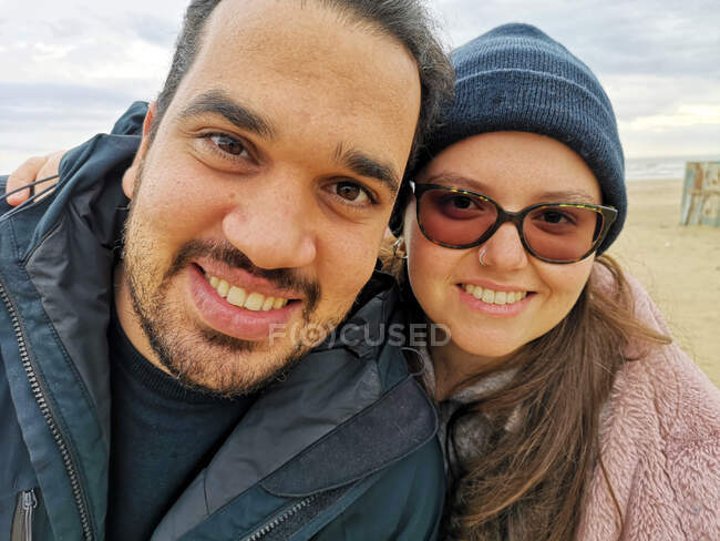 Retrato de una feliz pareja de pie en la playa, Puglia, Italia - foto de stock
