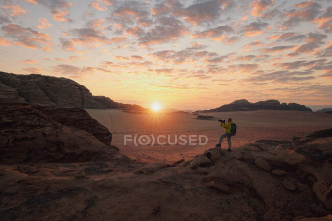 Чоловік, що стоїть у пустелі, фотографує на заході сонця, Ваді - Рам, Йорданія. — стокове фото