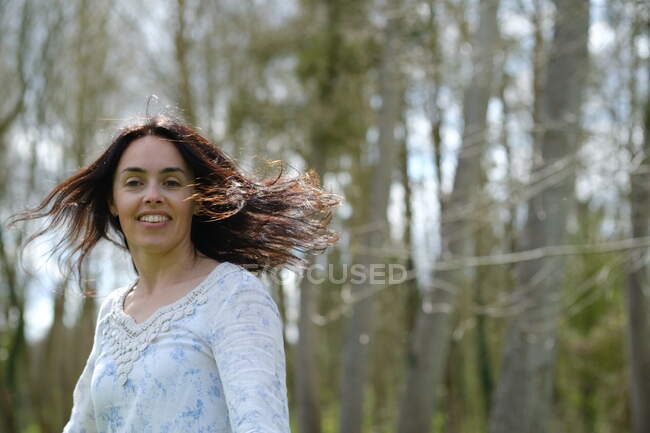 Portrait of a beautiful woman standing outdoors spinning around, France — Stock Photo