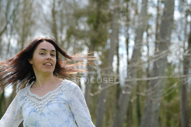 Portrait of a beautiful woman standing outdoors spinning around, France — Stock Photo