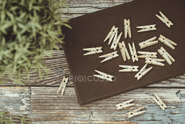 Top view of tray with wooden clothespins on wooden surface — Stock Photo