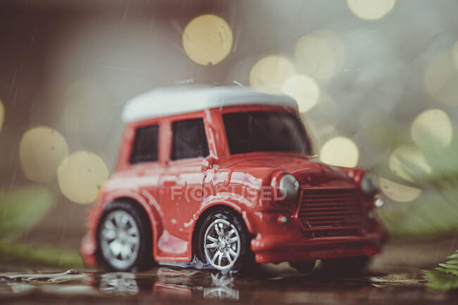 Carro de brinquedo vermelho com luzes bokeh, close-up — Fotografia de Stock