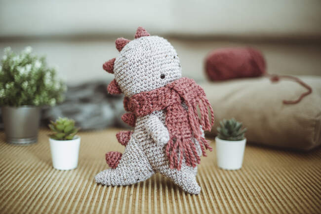 Jouet de dinosaure mignon tricoté à la main avec écharpe — Photo de stock