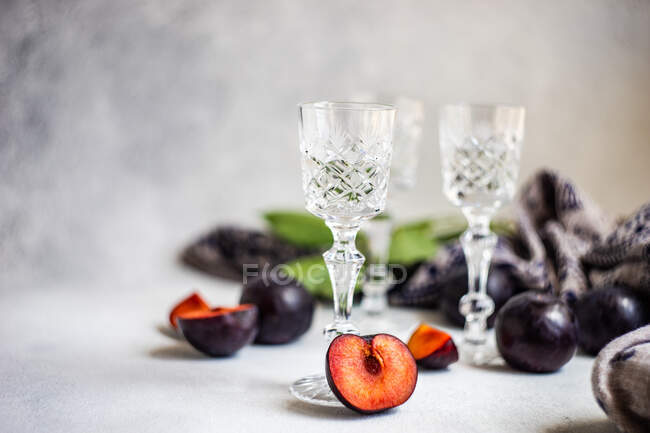 Pflaumenwodka in kalten Gläsern und frische Pflaumen auf einem Tisch — Stockfoto