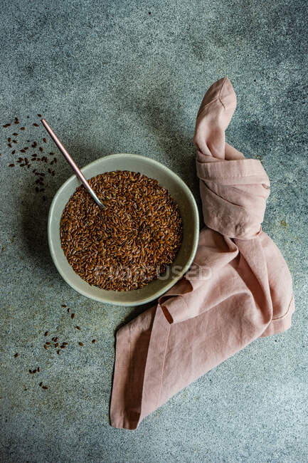 Ceramic bowl with organic and healthy flax seeds on concrete background — Stock Photo
