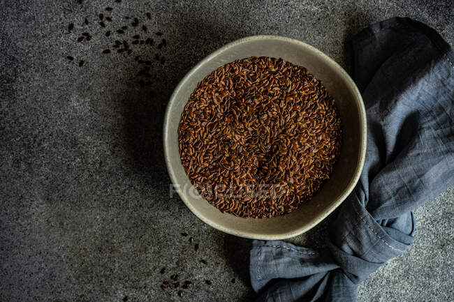 Tigela de cerâmica com sementes de linho orgânicas e saudáveis em fundo de concreto — Fotografia de Stock