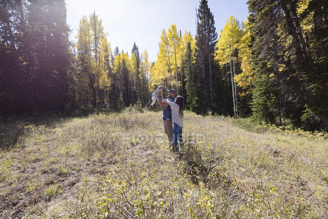 Портрет щасливої пари, що стоїть у лісі зі своєю донечкою з Каліфорнії (США). — стокове фото