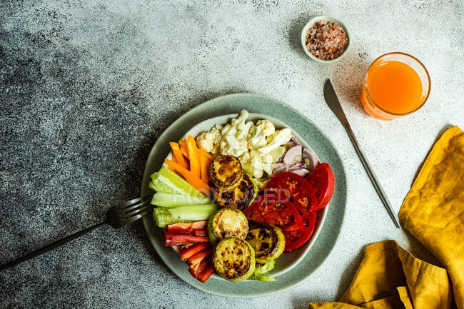 Platillo de verduras frescas con un huevo frito y un vaso de jugo de zanahoria - foto de stock