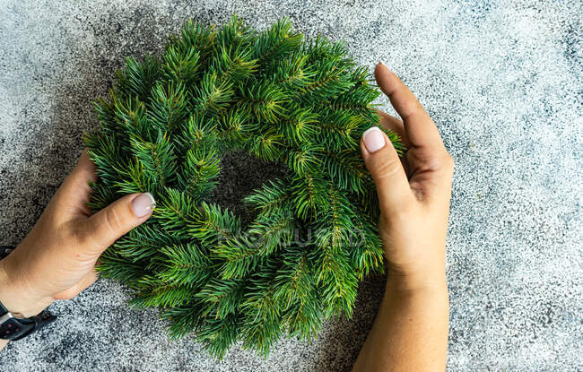 Overhead view of a woman holding a fir wreath — Stock Photo