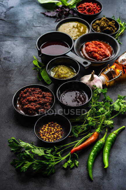 Overhead view of assorted herbs, spices, sauces and seasoning on a table — Stock Photo