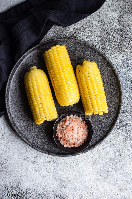 Plate of Corn cobs with pink himalayan salt — Stock Photo