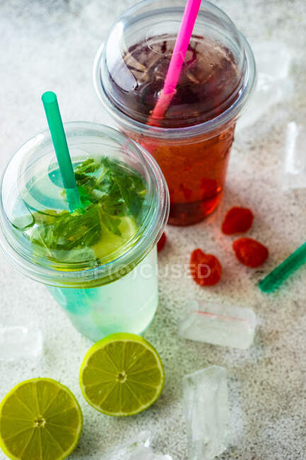 Strawberry lemonade and lime with mint lemonade on a  table with ice cubes, fresh lime and strawberries — Stock Photo