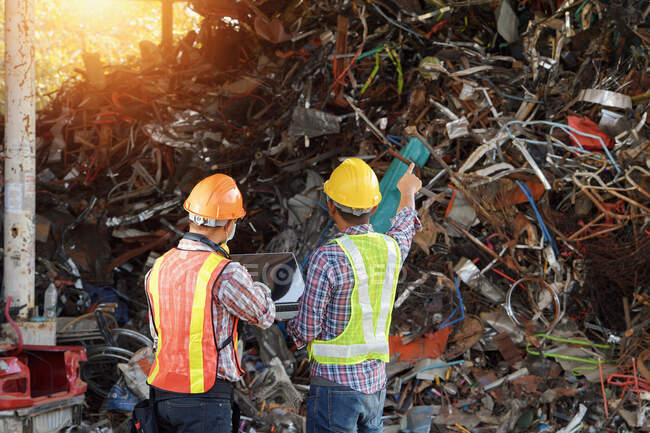 Rückansicht von zwei Arbeitern einer Recyclinganlage, Thailand — Stockfoto