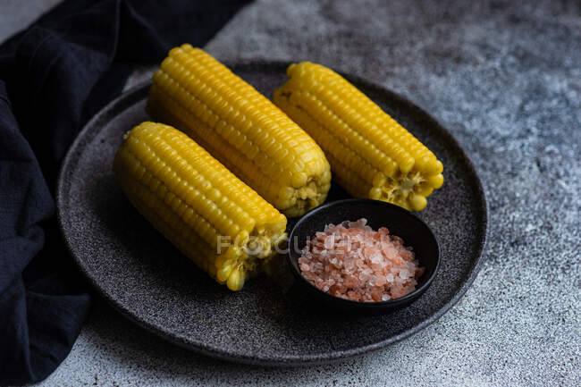 Prato de espigas de milho com sal rosa himalaia — Fotografia de Stock