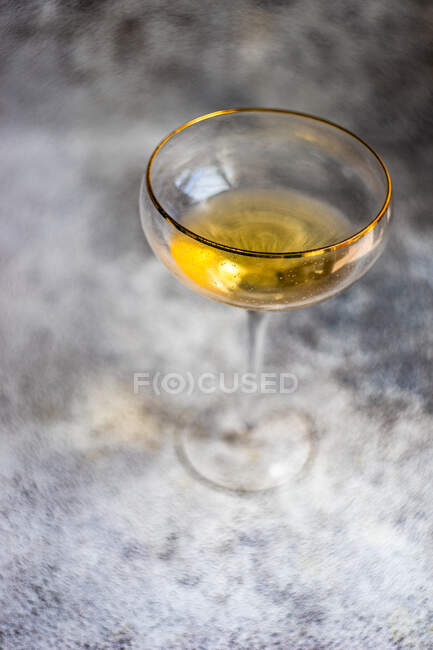 Copa de vino blanco en una copa de borde de oro - foto de stock