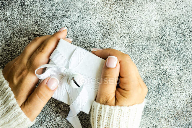 Вид сверху на женскую руку с подарком — стоковое фото