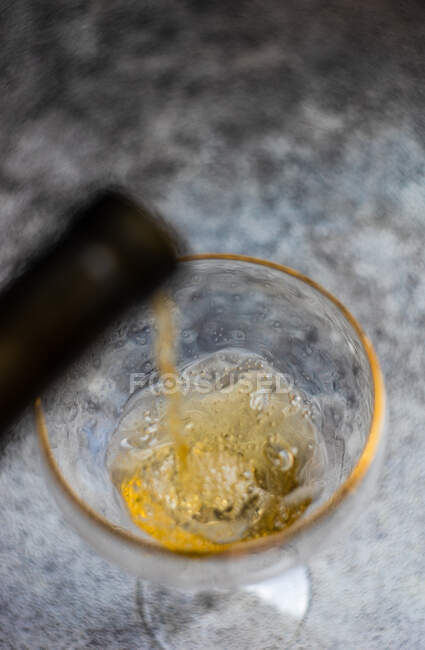 Gros plan d'un verre de vin blanc versé dans un verre à vin — Photo de stock