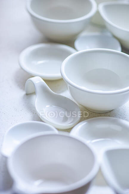 Primer plano de cuencos y platos de cerámica blanca - foto de stock