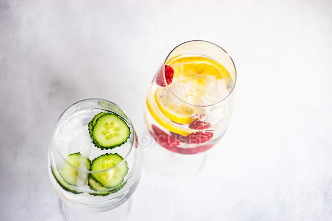 Dois copos de água gelada com pepino e framboesas com limão — Fotografia de Stock