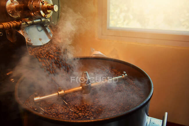 Close-up of coffee beans roasting in a coffee roaster — Stock Photo