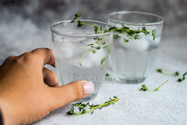 Woman's hand reaching for a martini cocktail drink — Stock Photo