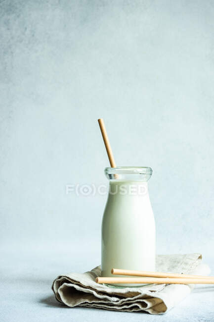 Garrafa vintage de leite em um guardanapo dobrado com palhas para beber papel — Fotografia de Stock