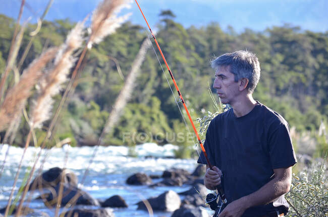 Hombre parado junto a un río pescando, Argentina - foto de stock