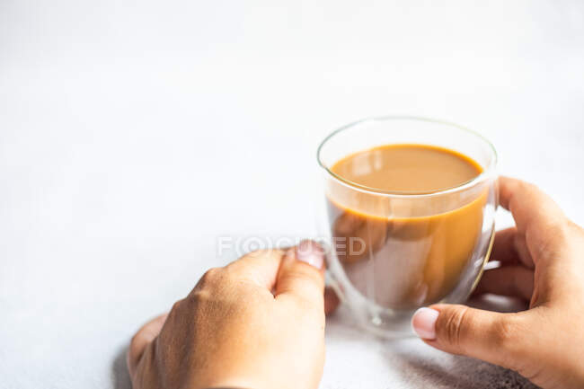 Mulher sentada em uma mesa com uma xícara de café — Fotografia de Stock