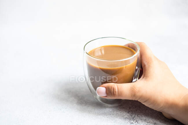 Mujer sentada en una mesa con una taza de café - foto de stock