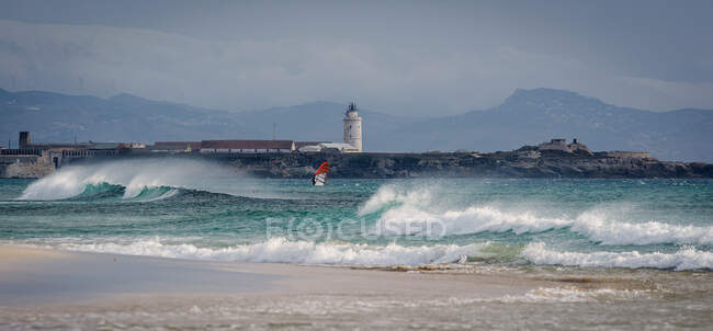 Pessoa kitesurf na frente do farol, Tarifa, Cádiz, Andaluzia, Espanha — Fotografia de Stock