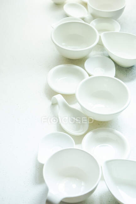 Overhead view of assorted white ceramic bowls and dishes — Stock Photo